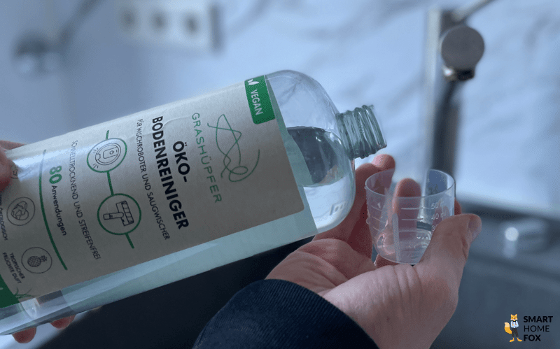 Der milde Grashuepfer Bio-Reiniger wird in den Wassertank eines Wischroboters gegeben.